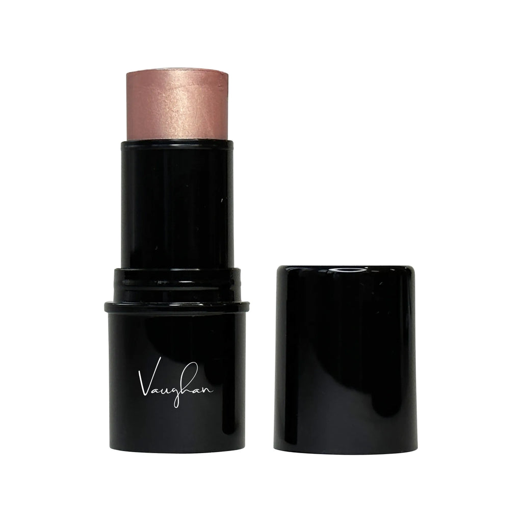 Black makeup stick with rose gold cap on a white background
